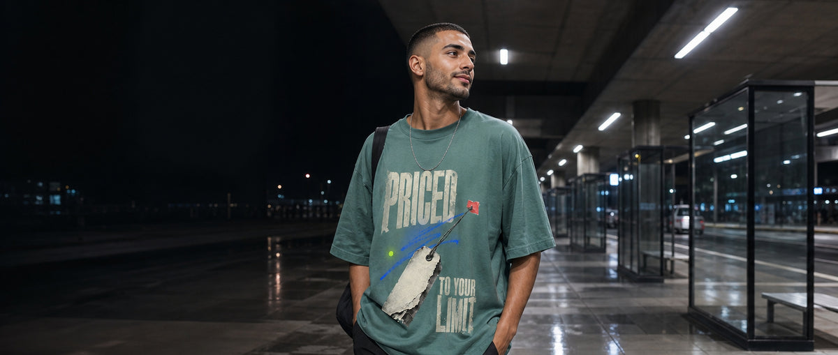 Adult model wearing the 3o1d PRICED TO YOUR LIMIT oversized T-shirt in Green Bay at a night bus interchange.