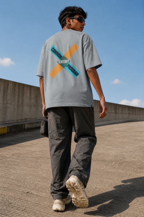 Model wearing the 3o1d COMMON ENEMY PROGRAM oversized T-shirt in Misty Grey, back graphic.