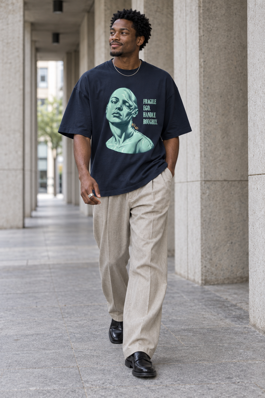 Model wearing the 3o1d FRAGILE EGO. HANDLE ROUGHLY. oversized T-shirt in French Navy, front graphic.