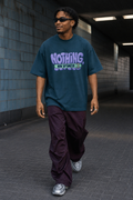 Model wearing the 3o1d NOTHING, NOW OPTIMIZED oversized T-shirt in Deep Teal, front graphic.