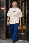 Model wearing the 3o1d PRE-OWNED BY NOBODY. oversized T-shirt in Cream, front graphic.