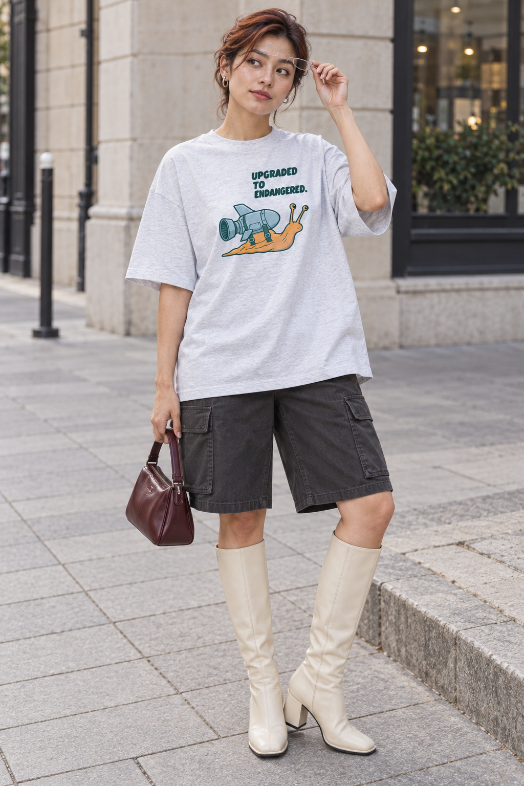 Model wearing the 3o1d UPGRADED TO ENDANGERED. oversized T-shirt in Cool Heather Grey, front graphic.